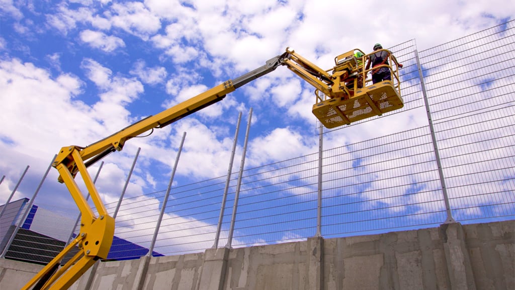 A worker on a yellow scissor lift.
