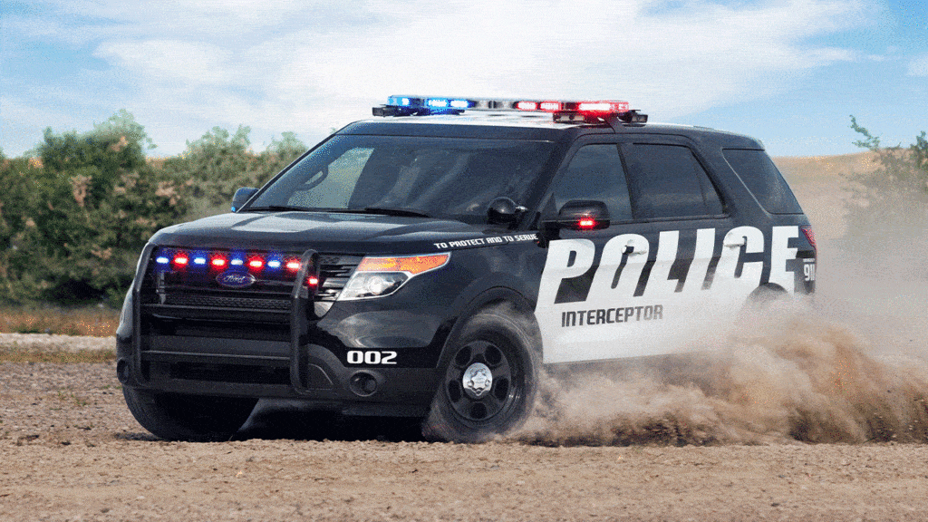 The ford explorer is driving on a dirt road.