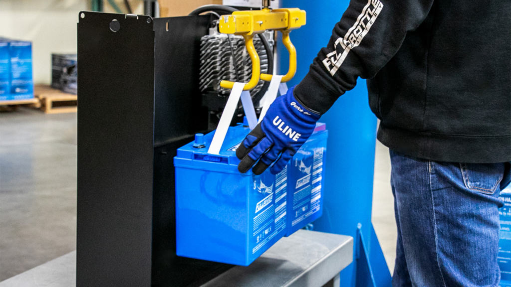 A man building a Fullriver Battery PowerVault in a warehouse.